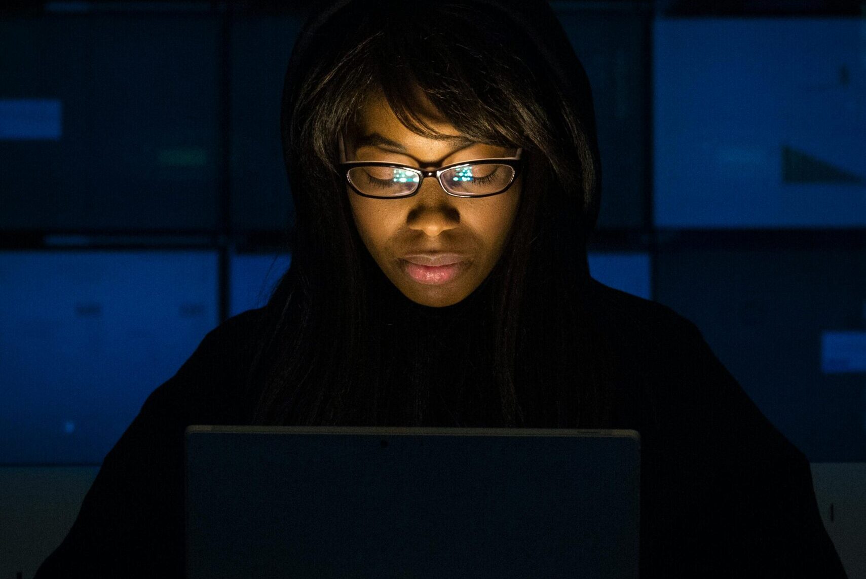 Woman immersed in laptop work during nighttime. Technology and focus in action.
